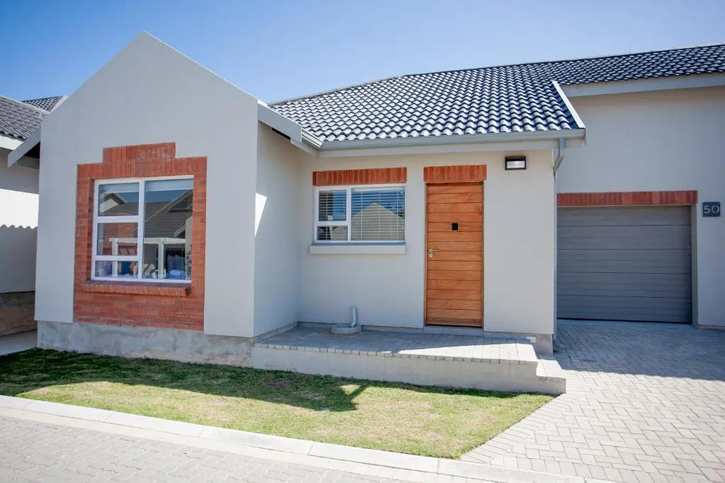Modern white townhouse with red brick accents and dark tile roof