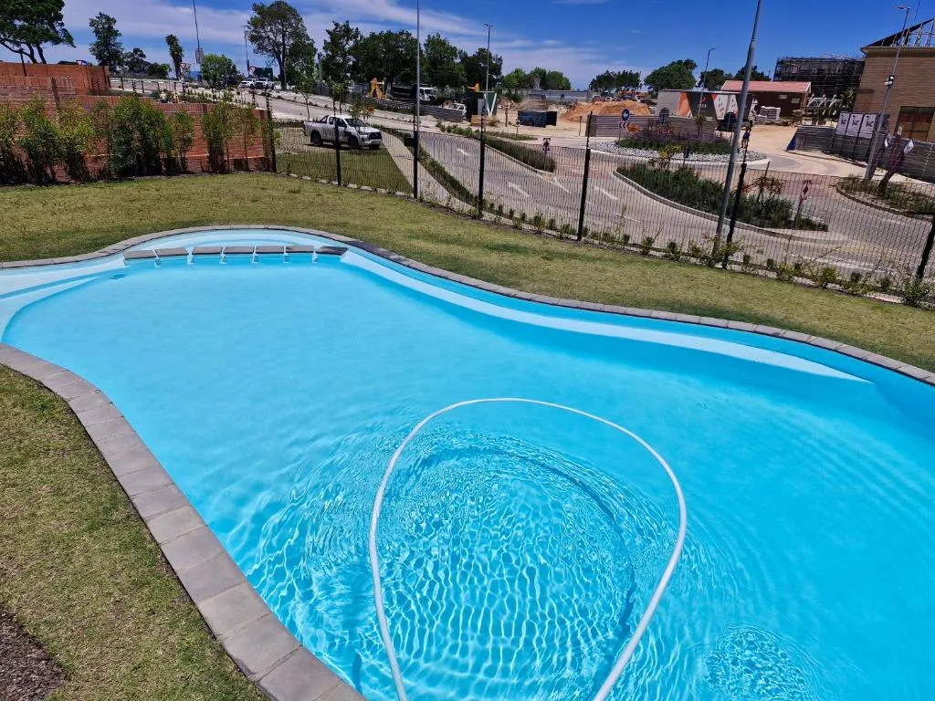 Bright blue swimming pool with curved edges and surrounding green lawn