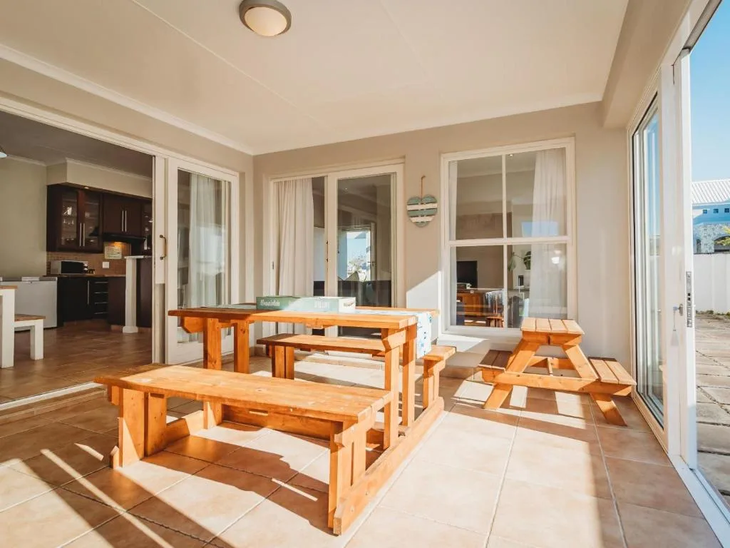 Wooden dining tables and benches on sunny outdoor patio area