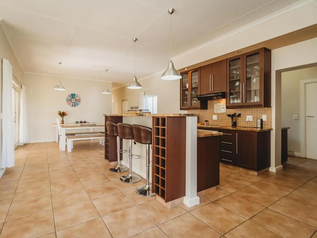 Modern kitchen with wooden cabinetry, island seating, and pendant lighting