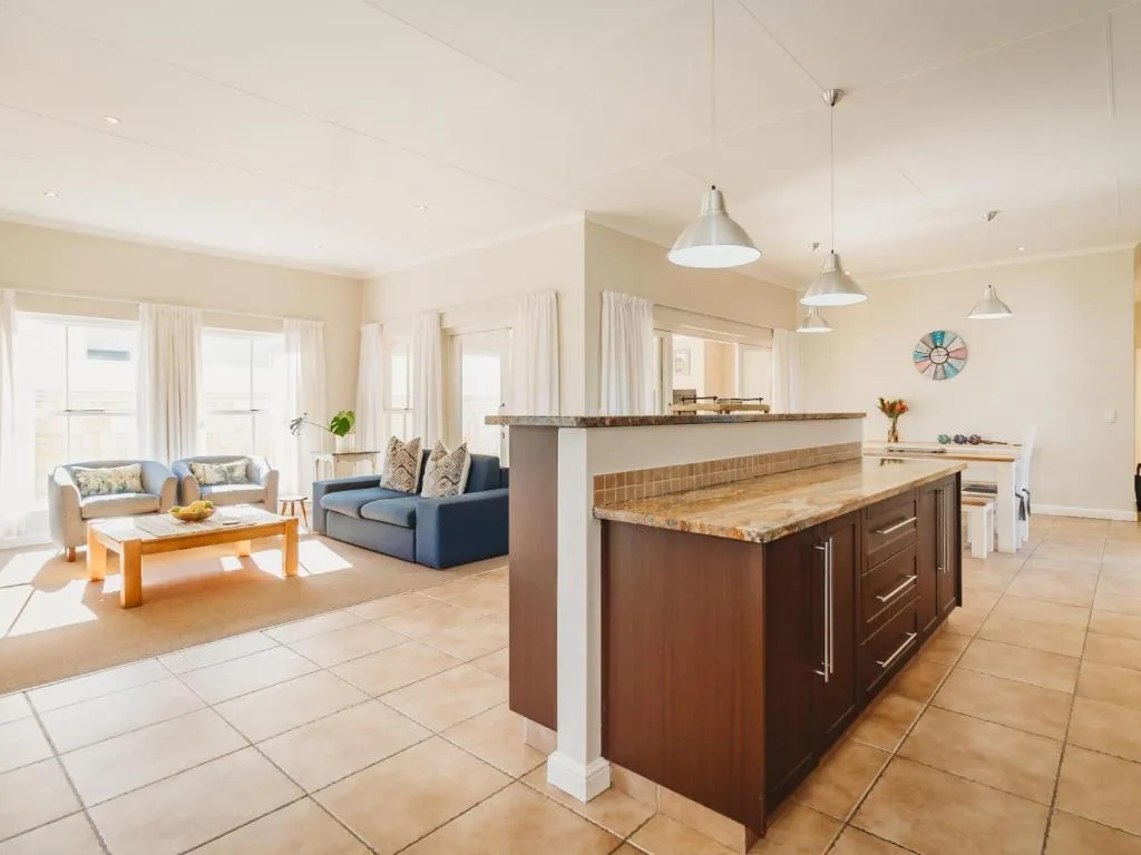 Open-plan kitchen with island counter and pendant lights overlooking lounge area