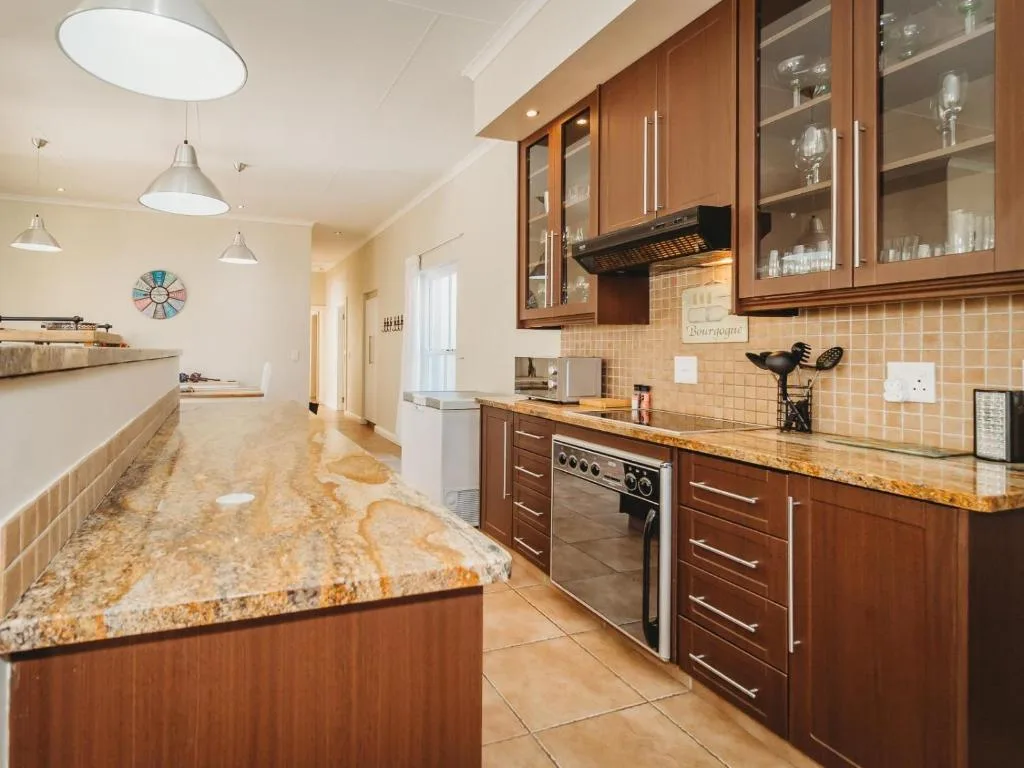 Modern kitchen with wooden cabinetry, granite countertops, and stainless steel appliances