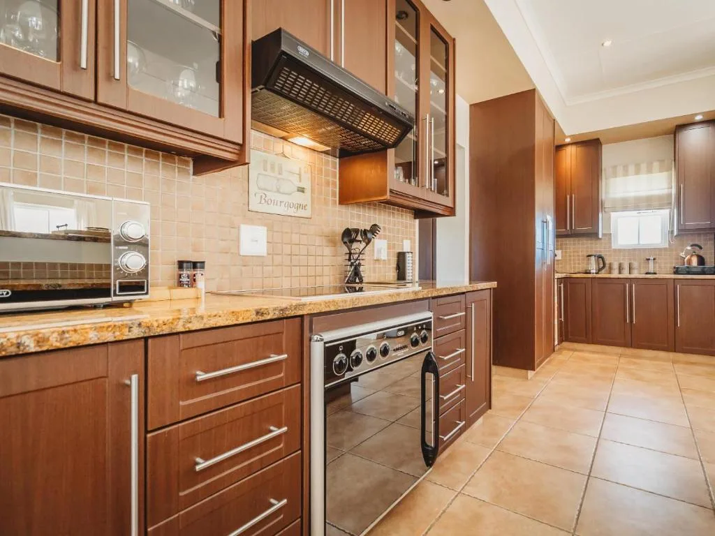 Modern kitchen with wooden cabinets, granite countertops, and stainless steel appliances