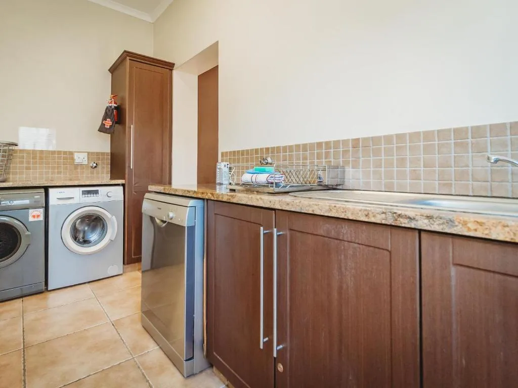 Modern kitchen with wooden cabinetry, granite countertops, and integrated appliances