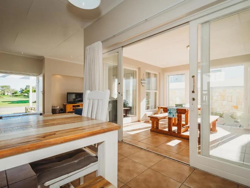 Spacious open-plan lounge with wooden counter, TV, and garden views