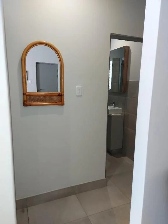 Modern bathroom with wooden framed mirror and dark vanity sink area