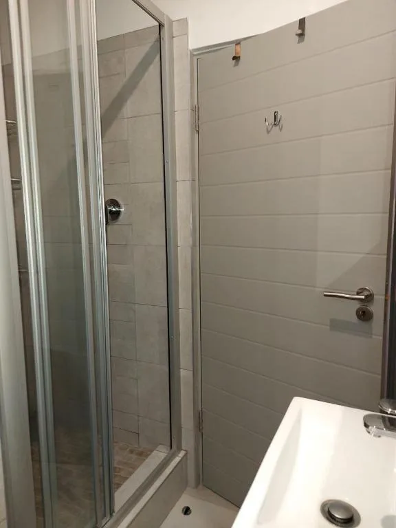 Modern bathroom with glass shower enclosure and white subway tile walls
