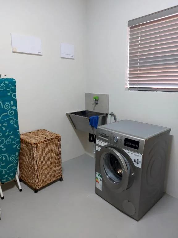 Modern laundry room with washing machine and wicker basket storage