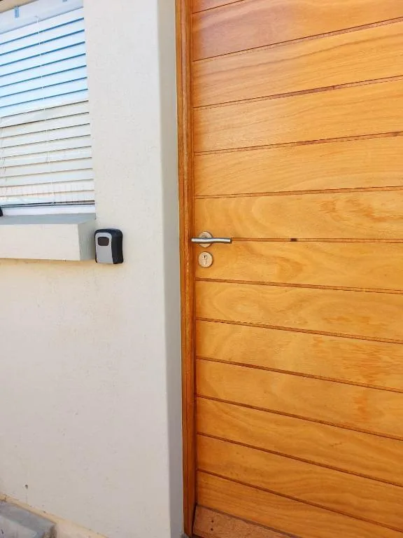 Wooden door with modern smart lock and access control device on wall