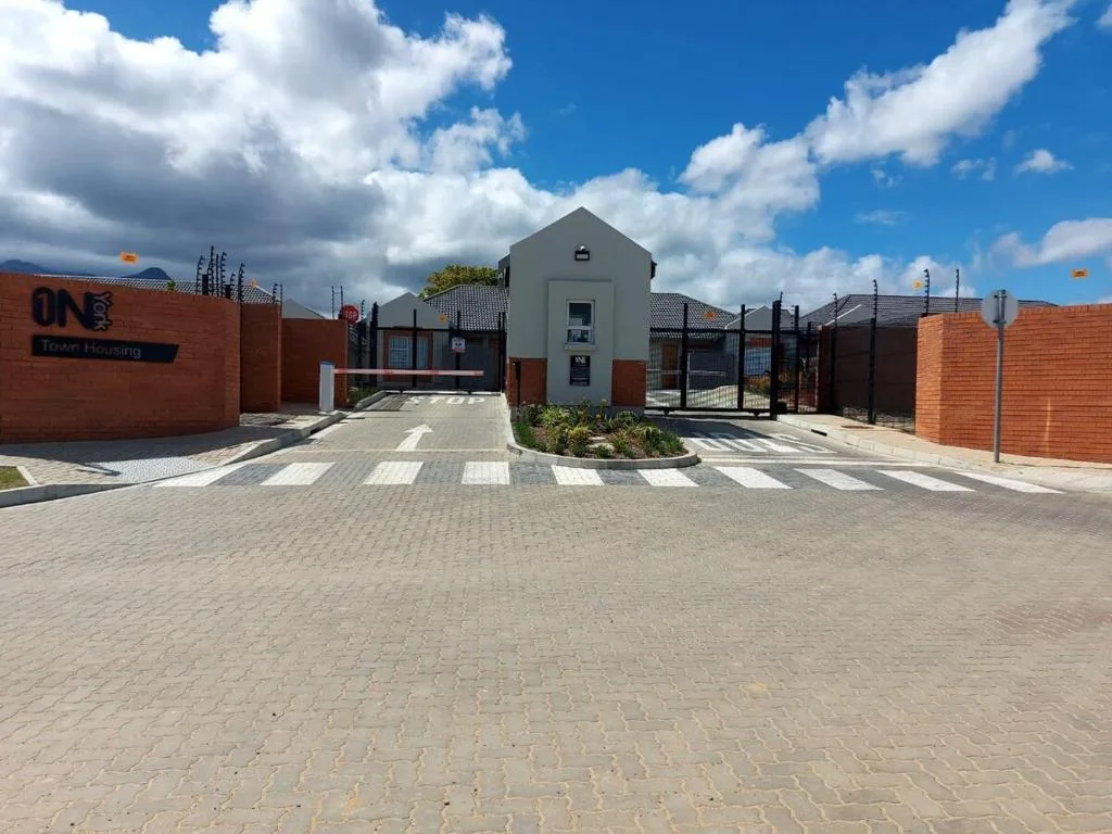 Modern gray cottage entrance with brick walls and paved driveway