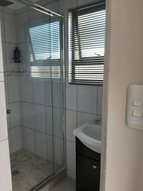Modern bathroom with glass shower enclosure and round sink vanity