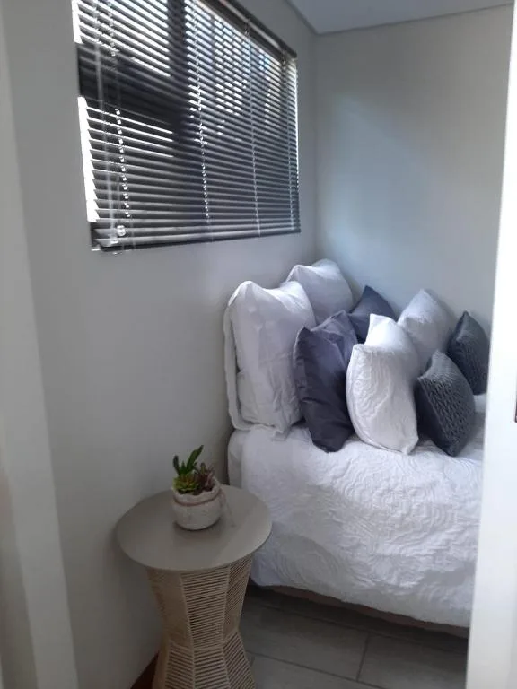 Cozy bedroom with neatly arranged pillows and fresh white bedding
