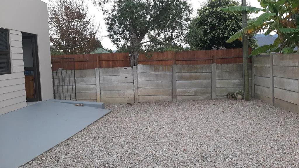 Spacious gravel courtyard with concrete and brick boundary walls