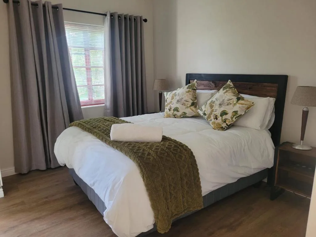 Well-appointed bedroom with queen bed, crisp white linens, and decorative pillows
