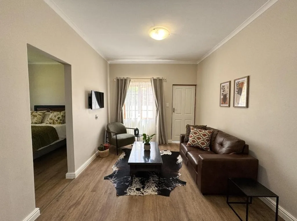 Spacious living room with brown leather sofa and modern furnishings
