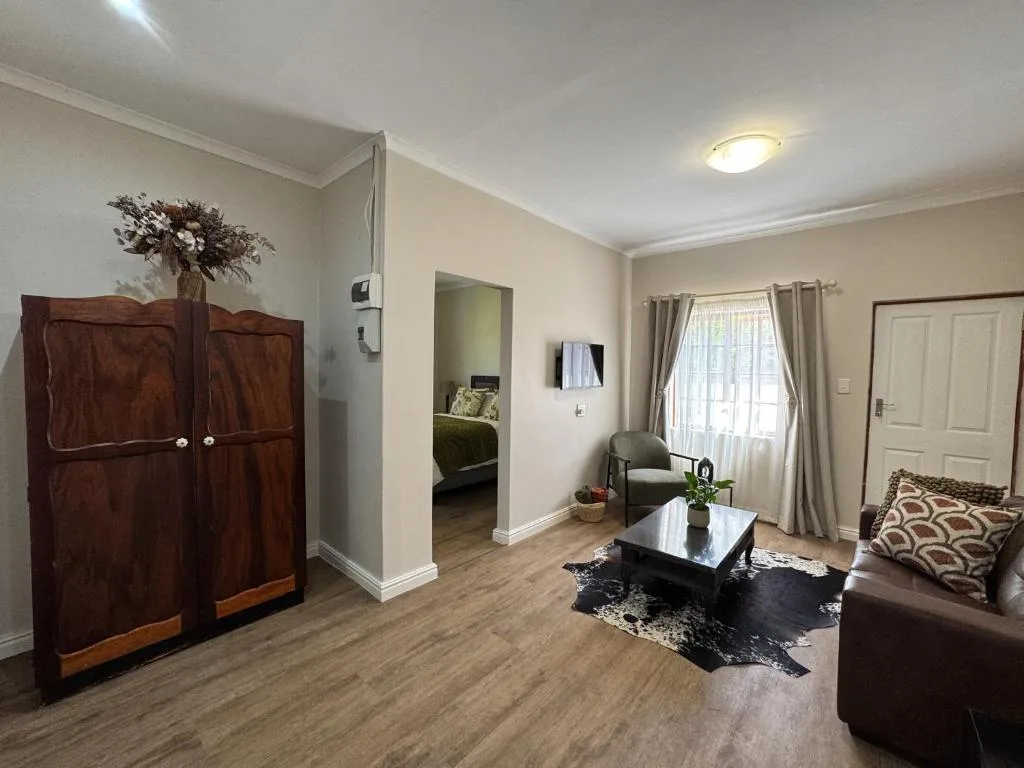 Spacious living room with brown leather sofa and wooden wardrobe
