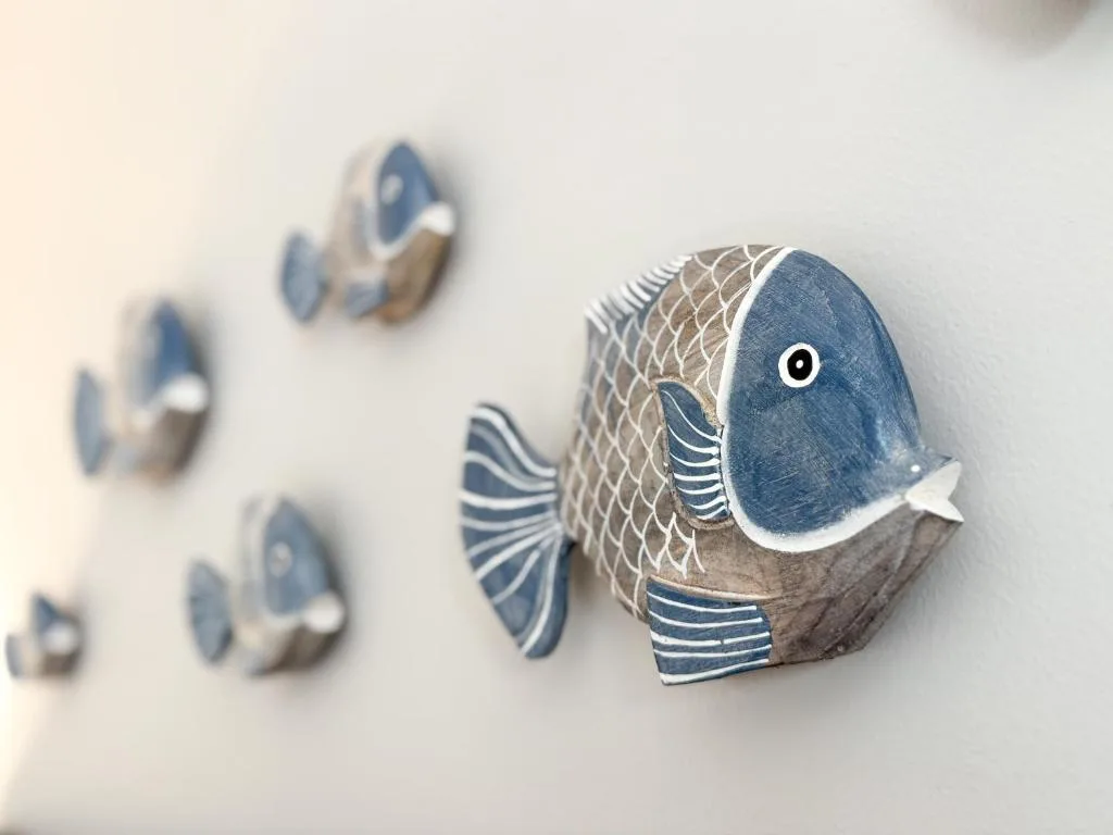 Decorative blue and white ceramic fish wall ornaments on white wall