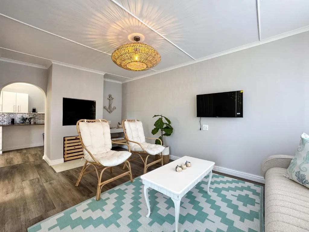 Modern lounge with rattan chairs, white coffee table, and wall-mounted TV