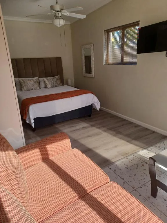 Bedroom with queen bed, ceiling fan, and natural light from windows