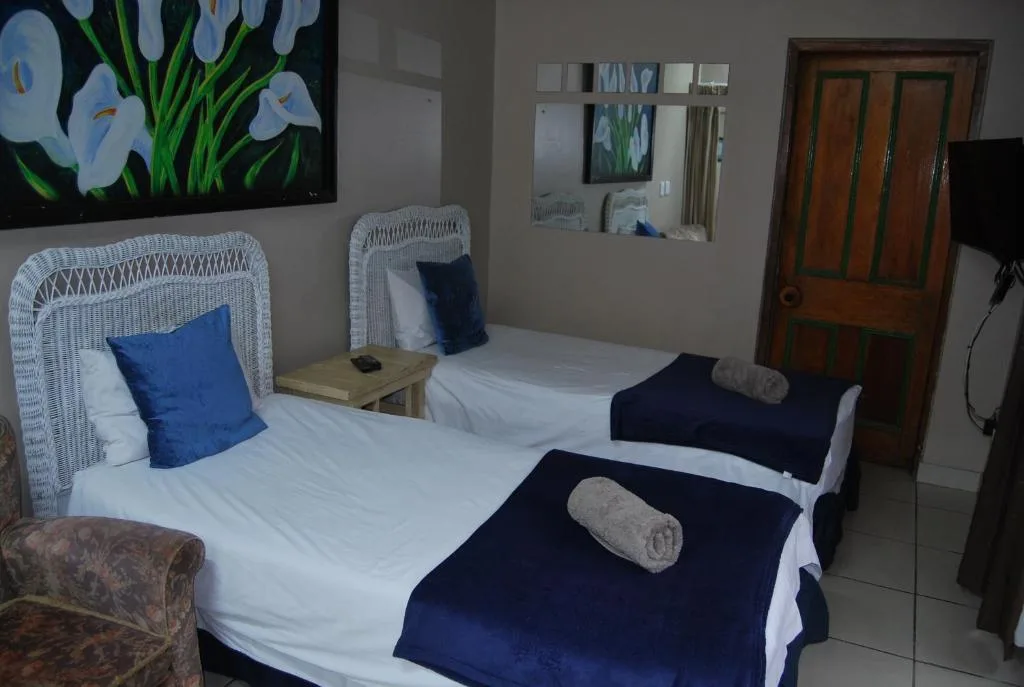 Twin bedroom with white wicker headboards and navy accents