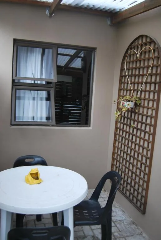 Small patio seating area with white round table and black chairs