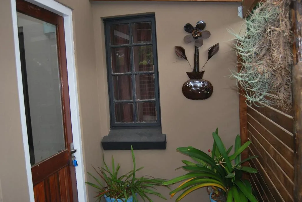 Interior wall with decorative metal flower art and potted plants