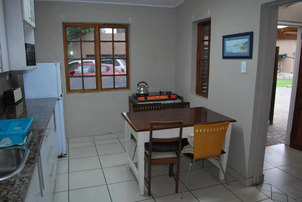 Open-plan kitchen and dining area with wooden table and yellow chairs