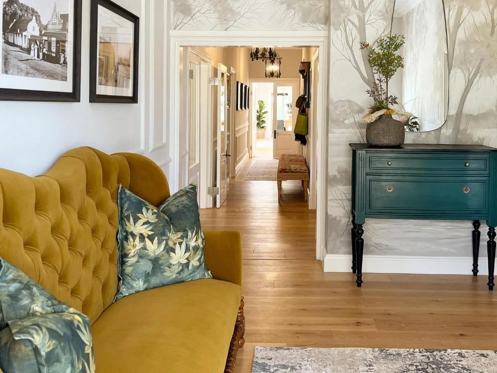 Elegant lounge with mustard velvet armchair and hallway view beyond
