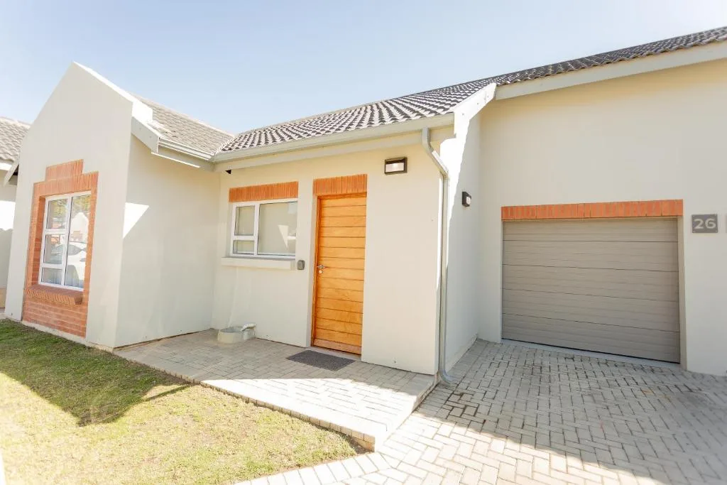 Modern cream townhouse with orange wooden door and garage entrance