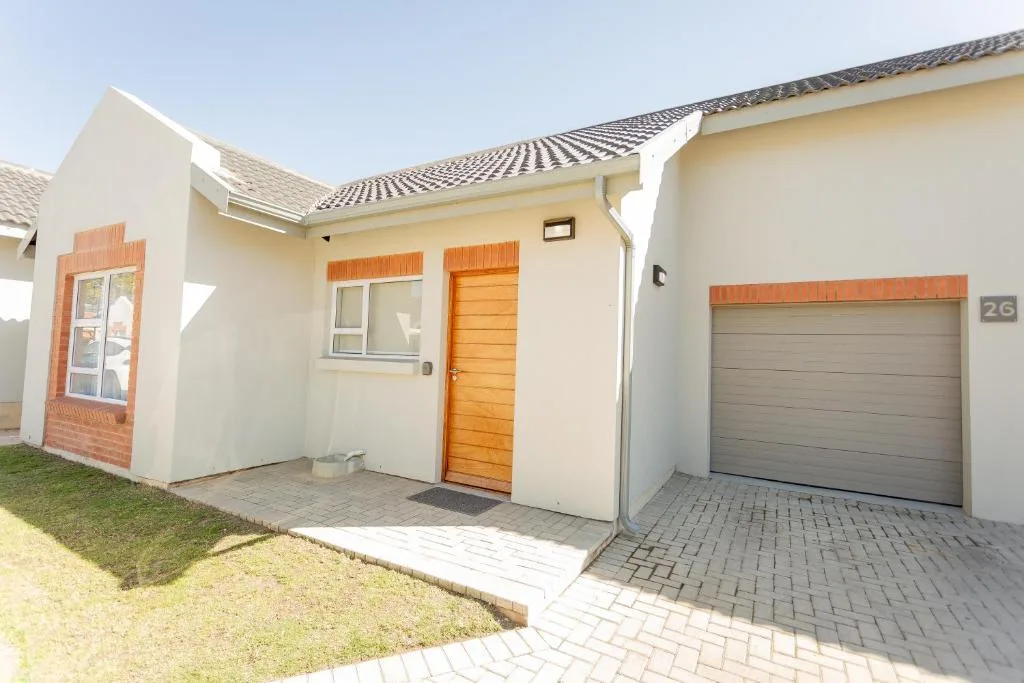 Modern cream townhouse with orange wooden door and garage entrance