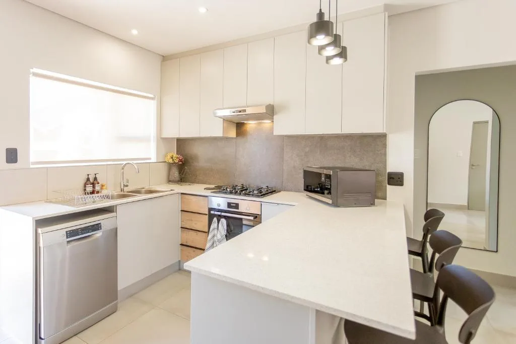 Modern kitchen with white cabinetry, stainless steel appliances, and island counter